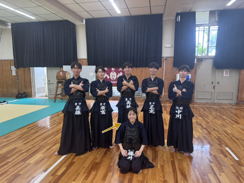 豊中高校剣道部の集合写真。手前中央の藤井さんを矢印で示しています。